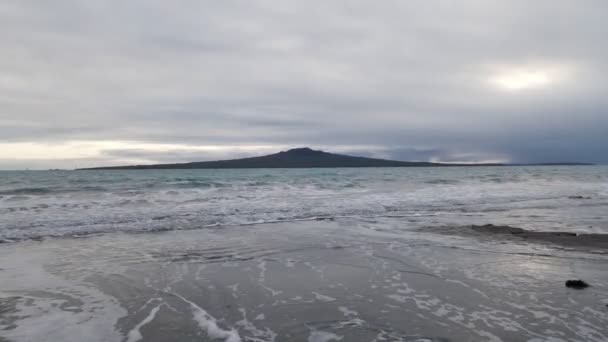 Malé Vlny Valící Břeh Nádhernou Sopkou Rangitoto Pozadí Dramatickými Mraky — Stock video