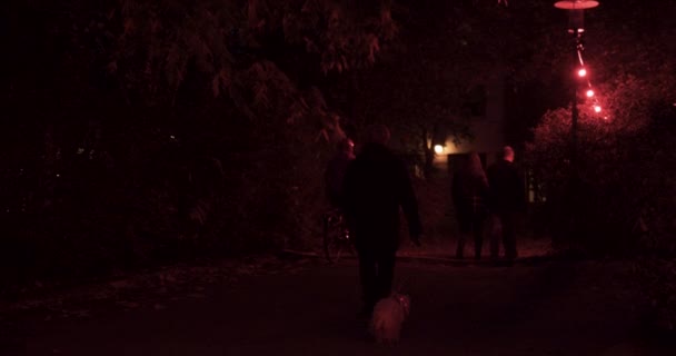 Άνθρωποι Περπατούν Κάτω Από Κόκκινα Αμυδρά Φώτα — Αρχείο Βίντεο