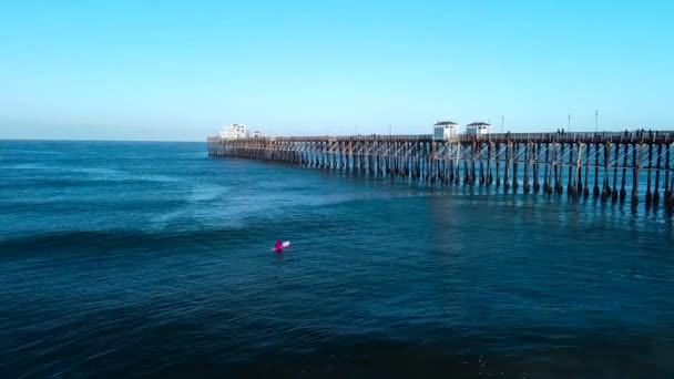 Oceanside Pier Langzame Pan Terug Met Surfer — Stockvideo