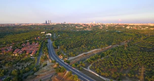 日没時にマドリードの塔や都市に向かって高速道路の上を飛行ドローン — ストック動画