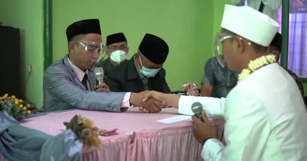 印度尼西亚穆斯林婚姻进程中的新娘和新郎在Akad Nikah宣布叫Ijab Kabul 向伊斯兰婚前协议握手 印度尼西亚人的婚礼 — 图库视频影像