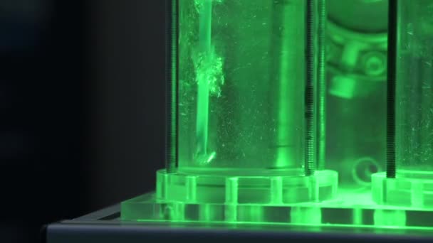电解器演示装置中带有水的管子中的氢气气泡 绿色灯 慢动作 — 图库视频影像