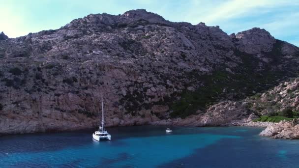 広大な青い海の横に巨大な崖に囲まれた豪華な白いヨットの回転式航空ビュー イタリア — ストック動画