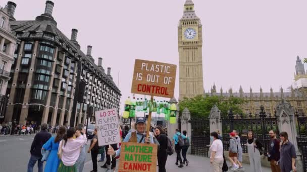 伦敦威斯敏斯特的老年男性气候活动家 高举气候变化和反塑料标志 抗议二氧化碳污染和气候危机以及自然保护和保护 — 图库视频影像