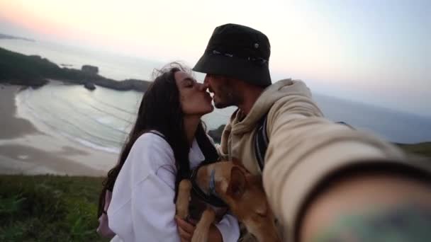 一对恋人带着他们可爱的小狗从令人赞叹的海崖上取下自己的东西 作为度假时的回忆 — 图库视频影像
