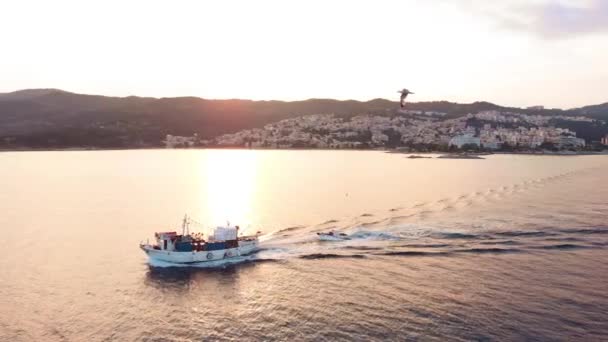 エーゲ海での木製漁船クルージングのバックライト付き空中パンニングショット 日の出シネマティック4K映像 — ストック動画