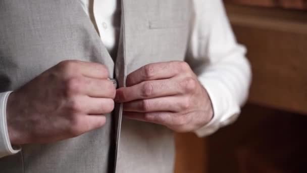 白いシャツの上にシンプルなグレーのウエストコートをボタンアップ男 閉じる — ストック動画