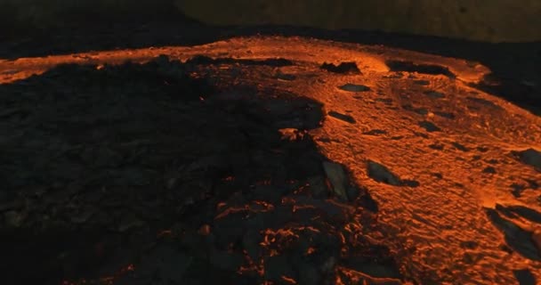 Fpv无人驾驶飞机在火山岩中央的一条流动的熔岩河上空低射向火山盆地 — 图库视频影像