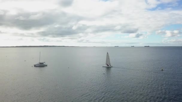 在平静的海洋日 多云的天空中 游艇接近系泊的双体船 — 图库视频影像