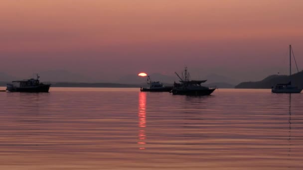 Boote Auf Ruhigem Ozeanwasser Bei Sonnenuntergang Mit Rotem Rauch — Stockvideo