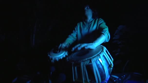 음악적으로 순간의 타블라 연주자가 어두운 야외에서 파란색 라이트를 천천히 물고기 — 비디오
