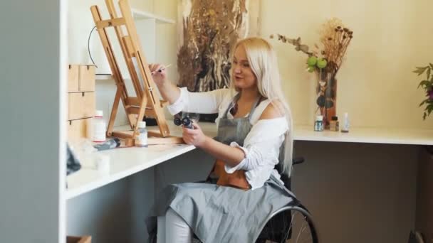 Tekerlekli Sandalyedeki Tatlı Sarışın Kız Çizer — Stok video