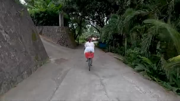 Seguindo Mulher Vestido Branco Uma Bicicleta Que Penetra Estrada Através — Vídeo de Stock