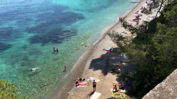 Turisti Che Nuotano Sull Acqua Limpida Prendono Sole Sulla Spiaggia — Video Stock