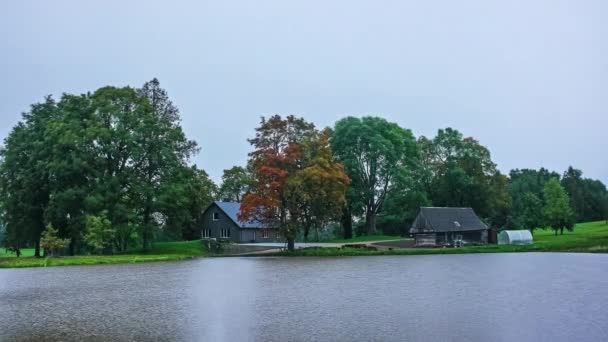 風の強い秋の日に湖で居心地の良いコテージ 時間の経過 — ストック動画
