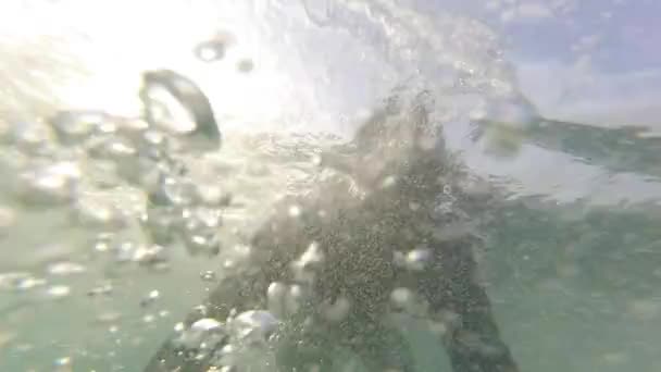 カスカイスでサーフィン 男は海の波を通過するために水中でサーフボードでダイビングします — ストック動画