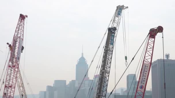 香港の金融街のスカイラインが背景にある間 多くのクレーンは エンジニアリング再開発商業プロジェクトの一環として建設現場に立っています — ストック動画