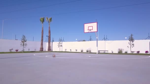 バスケットボールコートの真ん中でゆっくりと上昇するドローンの眺め — ストック動画