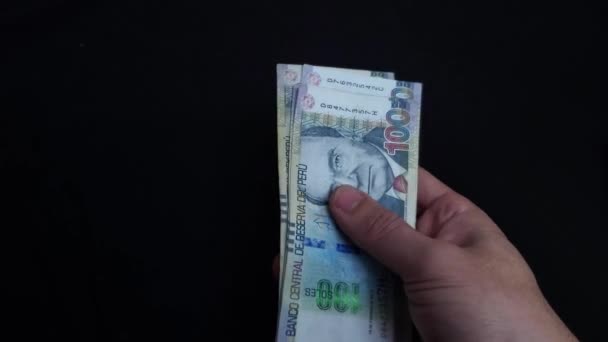 4K视频中的一只手拿着许多纸钞 秘鲁索尔是秘鲁的国家货币 手拿着钞票四处撒布 — 图库视频影像