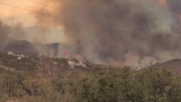 飞机在加利福尼亚野火上投放红色防火灭火剂 遥不可及 — 图库视频影像