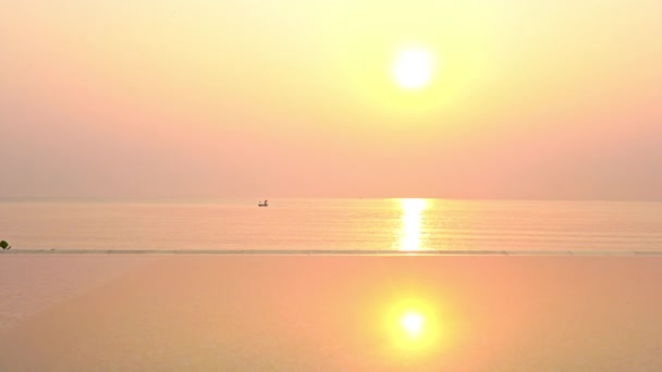 穏やかな熱帯海の上の黄金の夜の太陽とホライズン島の孤立したボート フルフレーム — ストック動画