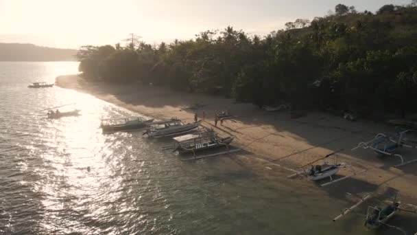 在印度尼西亚伦博克岛日落时停泊在海滩海岸线上的船只 — 图库视频影像