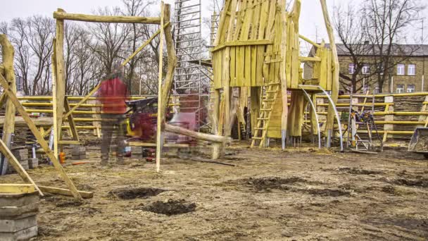 労働者の静的なショット曇りの日にタイムラプスで木製の子供の遊び場を構築する忙しい建設 — ストック動画