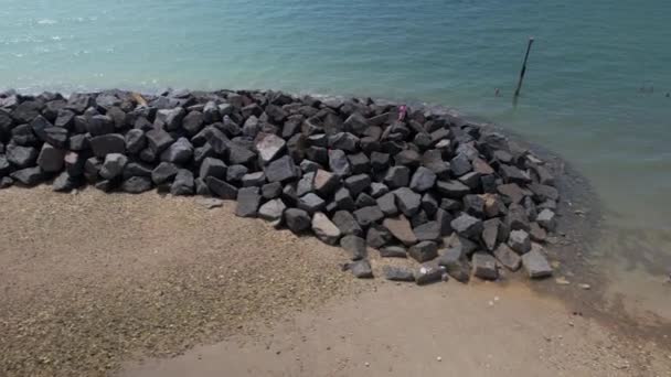 英国西萨塞克斯郡Elmer Sands海滩保护海岸线侵蚀的破碎机岩石 空中侧向飞行 — 图库视频影像