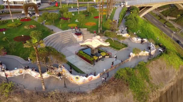 位于秘鲁利马Miraflores区的一个名为 Parque Del Amor 的公园周围的Drone 4K视频 一对情侣在绿树绿草环绕下接吻的纪念碑 公园里很多人 — 图库视频影像