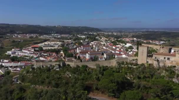 オビドス要塞の壁やポルトガルの日当たりの良いオエステの村からの空中の景色 引き戻す ドローンショット — ストック動画