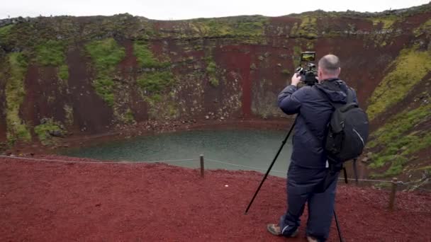 Male Photographer Setting Camera Kerid Volcano Iceland Gimbal Video Walking — Stock Video