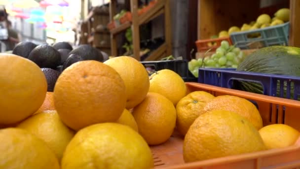 新鲜橙子在市场上销售 市场上新鲜的水果 农贸市场上有水果的货架 露天地方食品市场的盒子里有漂亮的橙子 — 图库视频影像