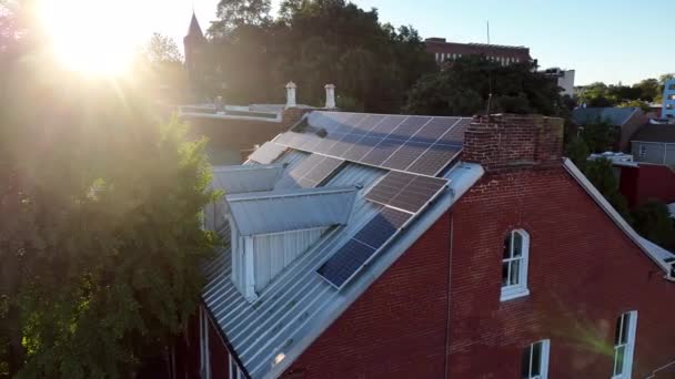 大きなレンガ造りの家の屋根の上に太陽電池パネル 太陽光パネルから反射する明るい太陽光線の空中ビュー 再生可能エネルギーのテーマ — ストック動画