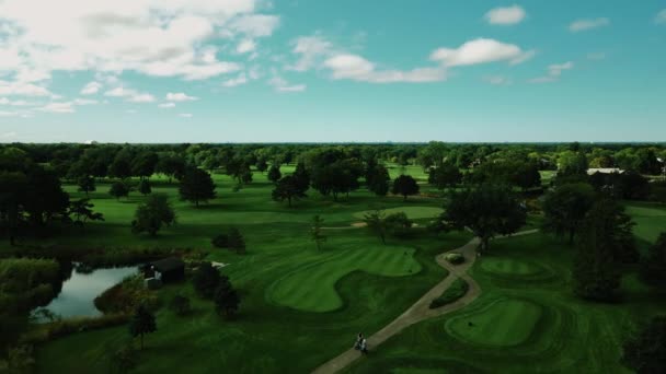 昼間に白い雲が通過する米国イリノイ州ノースブルックのゴルフクラブの空中ドローンの概要 — ストック動画