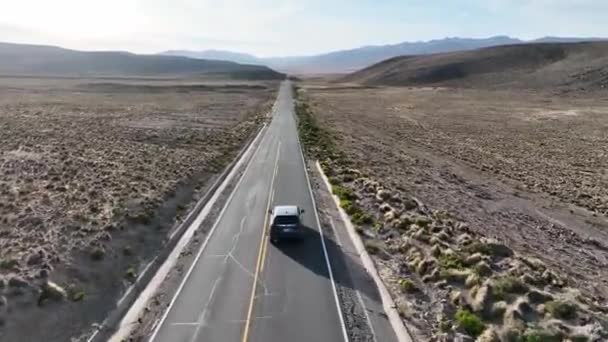 ペルーのアンデス山脈のアレキパとコルカ峡谷の間の道路の息をのむような乾燥した風景を通って車に乗る無人機 — ストック動画