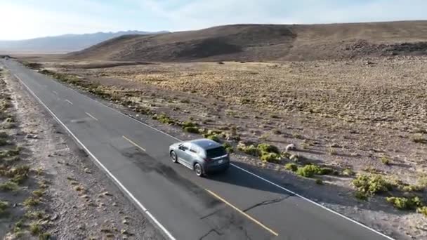 ペルーの風景のチバイにつながる山に囲まれた車の周りを周回する滑らかで美しい空中ドローンショット — ストック動画