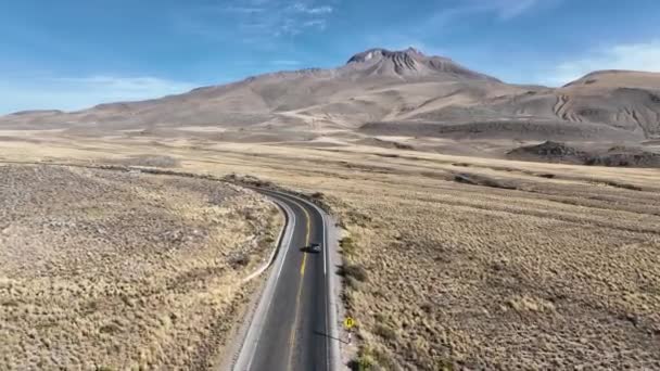 南米ペルーのアンデス山脈のアレキパとコルカ峡谷の間の道路の広大で息をのむような景観を通って車に乗る無人機 — ストック動画