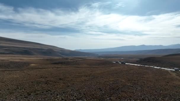 乾燥した草原の上を横断し 美しい曲線を描く山道と広大なペルーの高速道路の風景をオープン空でチバイに明らかにするドローン — ストック動画
