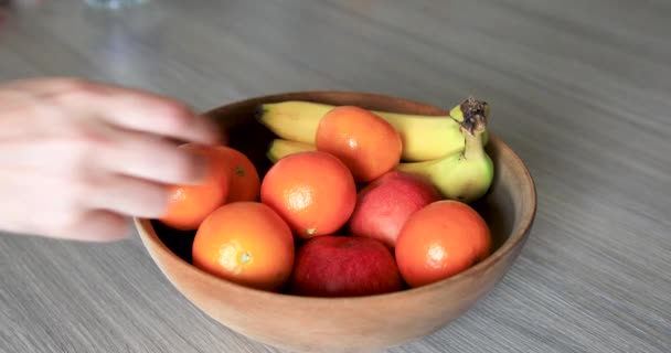 Πρόσωπο Επιλέγοντας Φρέσκο Μήλο Από Φρούτα Μπολ Τοποθετείται Ξύλινο Τραπέζι — Αρχείο Βίντεο