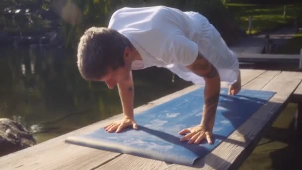 Vit Vuxen Man Gör Yoga Och Sträcker Sig Träbro Över — Stockvideo
