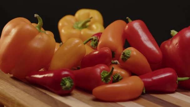 Pile Bell Peppers Spinning Cutting Board Black Background — Stock Video