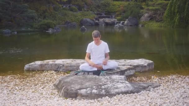 Weiße Kaukasische Männer Meditieren Sitzend Auf Einem Felsen Einem Teich — Stockvideo