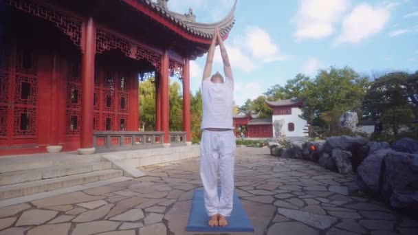 Кавказький Дорослий Самець Практикує Йогу Навколишнє Середовище Традиційним Китайським Храмом — стокове відео