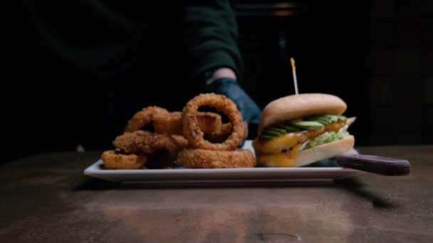 一个鸡肉汉堡和一个洋葱圈被推入框架 — 图库视频影像