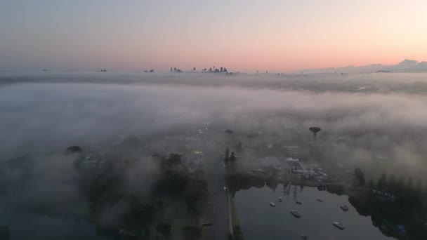 霧のシドニーのスカイライン日の出 美しい逆プリンセスハイウェイを朝の交通量で飛んでいます ショットを確立するシネマティック空中プルバック — ストック動画