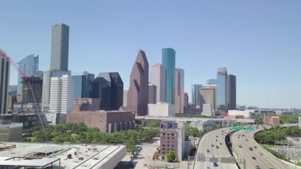 I10とI45の交差点からヒューストン中心部を撮影中の航空機のプッシュ 北行きのドローンが高層ビルが立ち並ぶヒューストンのダウンタウンの侵入撮影 アメリカの大都市 日曜日と高速道路で忙しい交通 — ストック動画