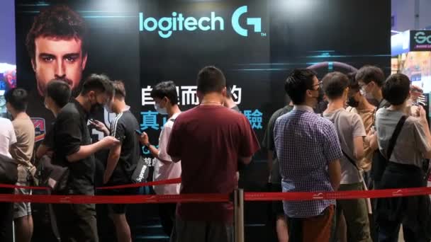 中国からの訪問者は 香港のコンピュータと通信フェスティバル中にロジクールブランドのブースにアクセスするために並んでキュー — ストック動画