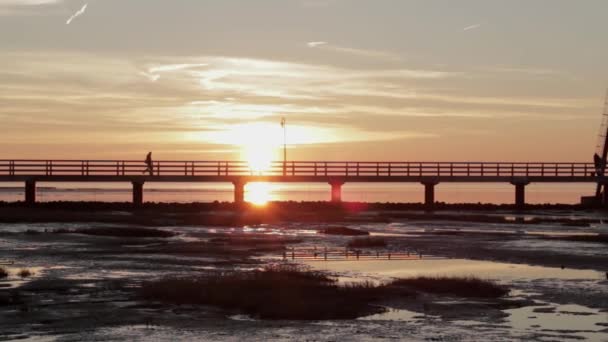 Человек Ходит Небольшому Мосту Перед Старинным Маяком Закате — стоковое видео
