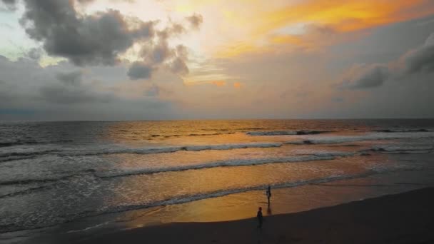 美しいスミニャックと映画の波と人々が歩くバリのダブルシックスビーチドローン映像 この映像は1080年の日没時に撮影された — ストック動画