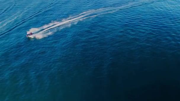 スペインのカボピノの海岸線上空を飛行するドローン 水上のジェットスキーと水平線に傾斜カメラ — ストック動画